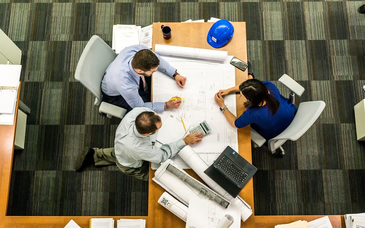 Consulting team reviewing technical plans and commercial agreements